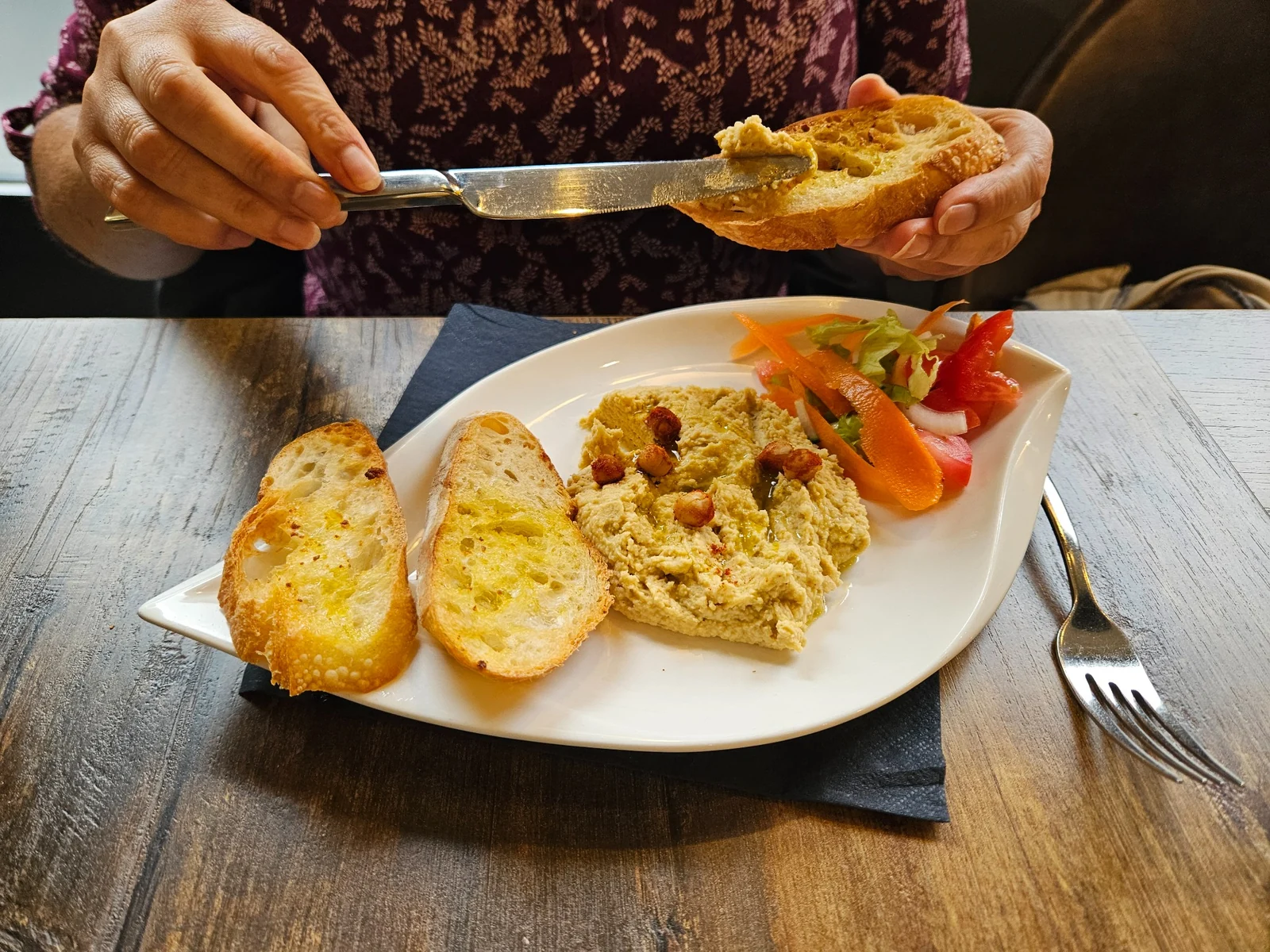 Une personne déguste une tartine au restaurant