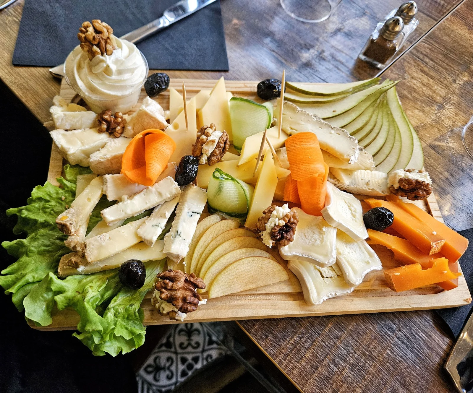 Une planche de fromages, fruits et légumes colorés
