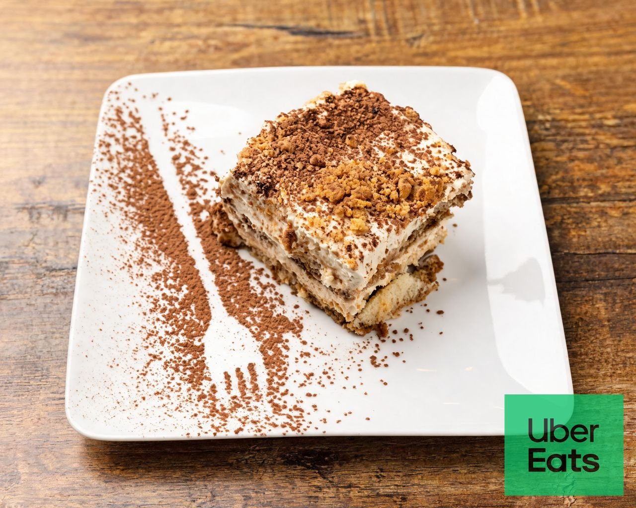 Un tiramisu présenté sur une assiette décorée de cacao