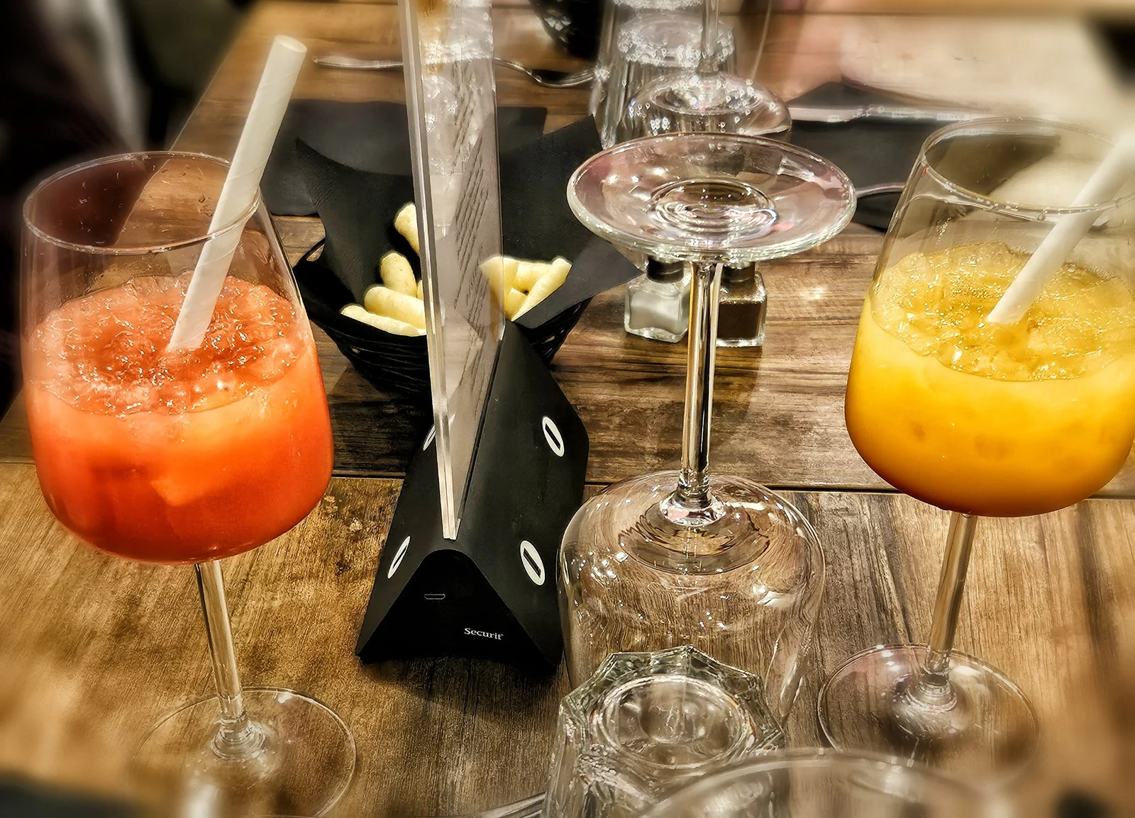Des verres orange et rouge autour d’une table